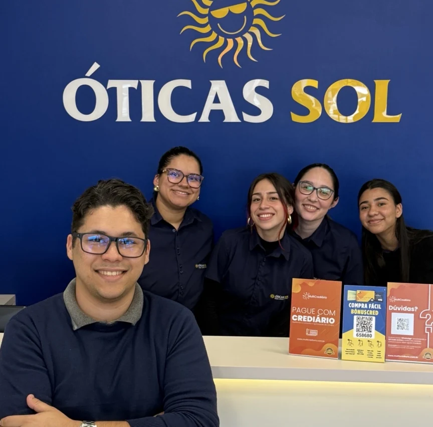 Augusto com integrantes da equipe em uma loja Óticas Sol