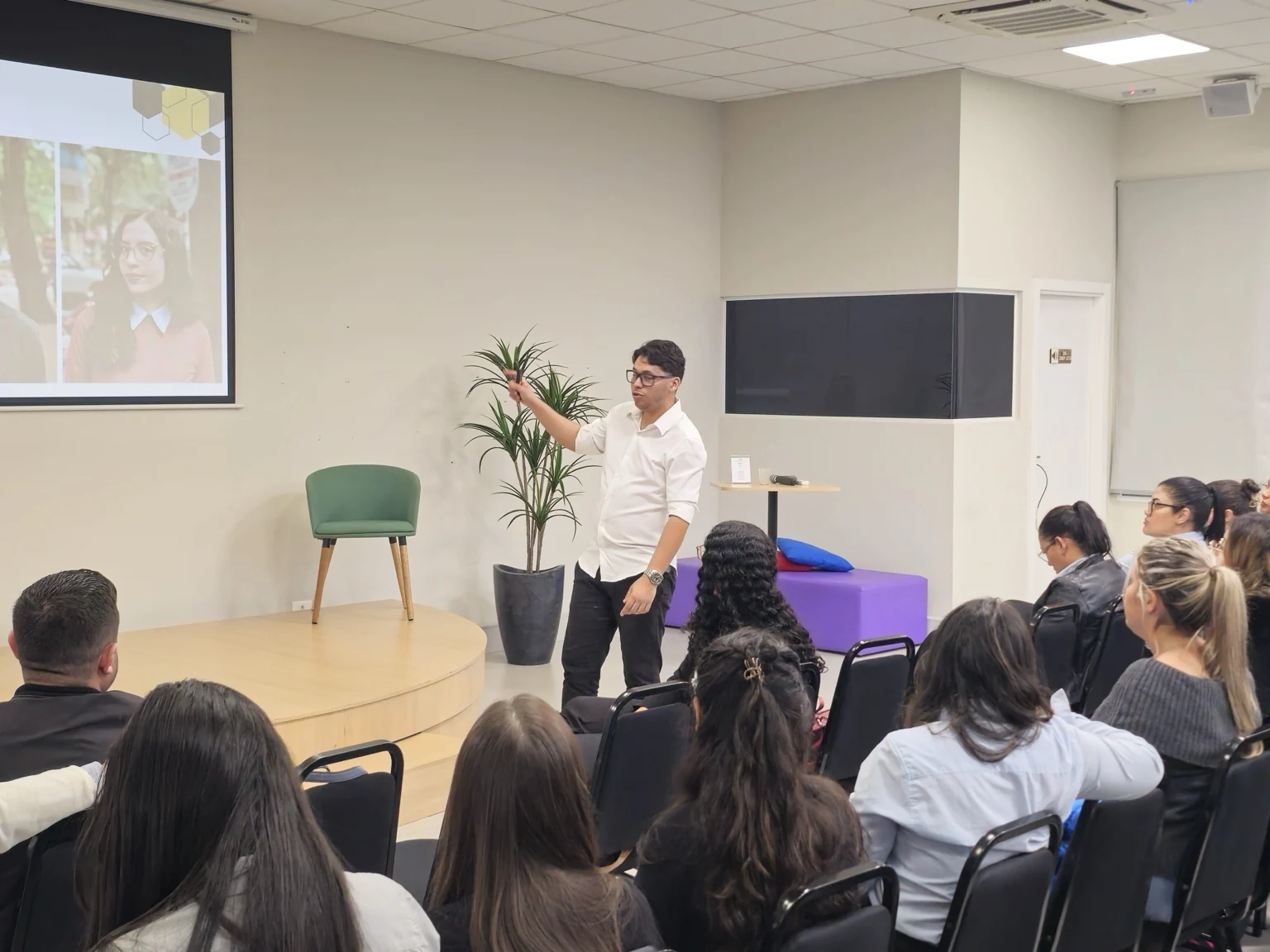Augusto apresentando para uma plateia em ambiente profissional