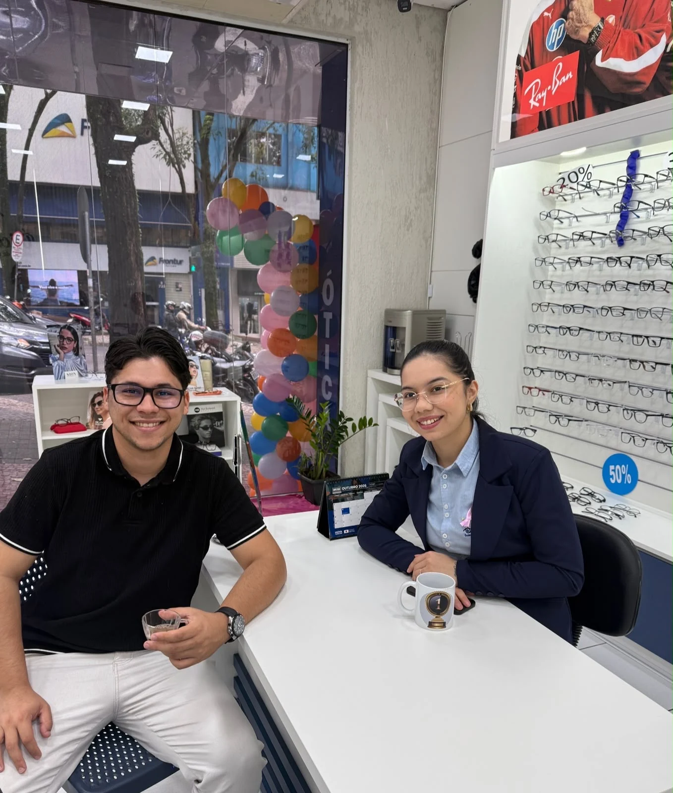 Augusto conversando com profissional durante visita ao ambiente de uma ótica